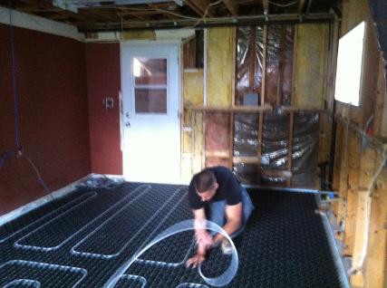 Plumbing apprentice installing floor radiant heat piping on an Uponor Fast Track application.